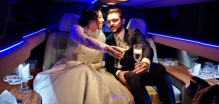 Casal brindando com champanhe no interior iluminado de limousine da Town Car Curitiba